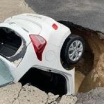 Dilanda Cuaca Buruk, Sebuah Mobil Masuk Lubang Jalan